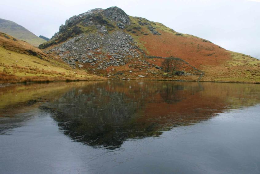 20060205-103746.jpg - Sunday began with an ascent of Clogwyn y Garreg, here reflected in the icy surface of Llyn y Dywarchen